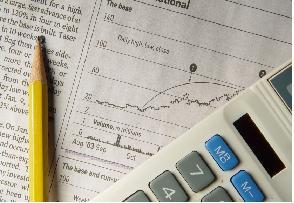 Newspaper stock chart with calculator and pencil